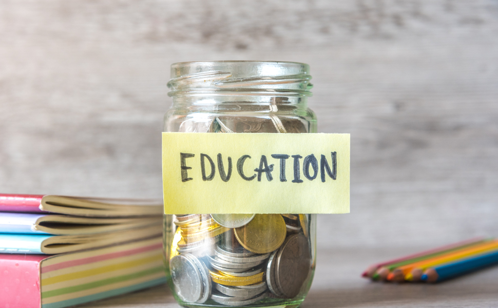 Ein mit Münzen gefülltes Glas mit angeklebtem Zettel + Beschriftung 