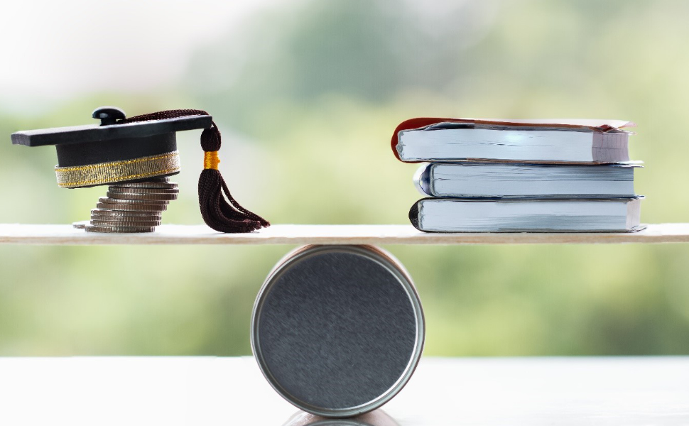 Absolventenkappe und Bücher befinden sich auf einer Waage