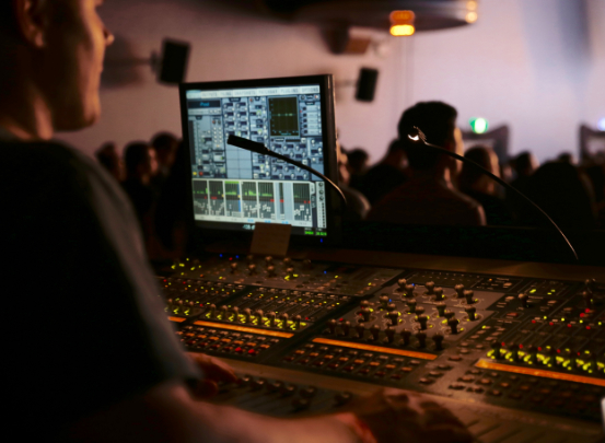 Ein Mediengestalter für Bild und Ton nimmt Aufnahmen auf einem Event auf. 