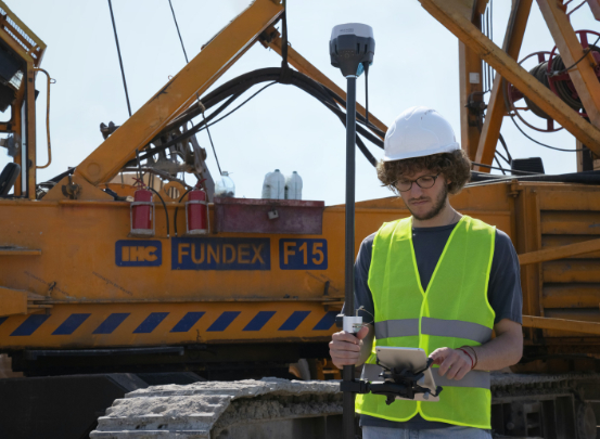 Ein Vermessungstechniker vermisst das Gelände.