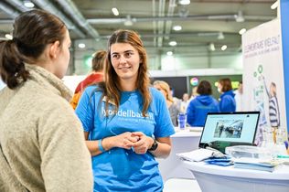 Eine junge Frau berät eine Jugendliche am Messestand