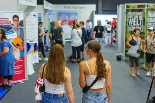 Zwei Teenager gehen durch die Messehalle