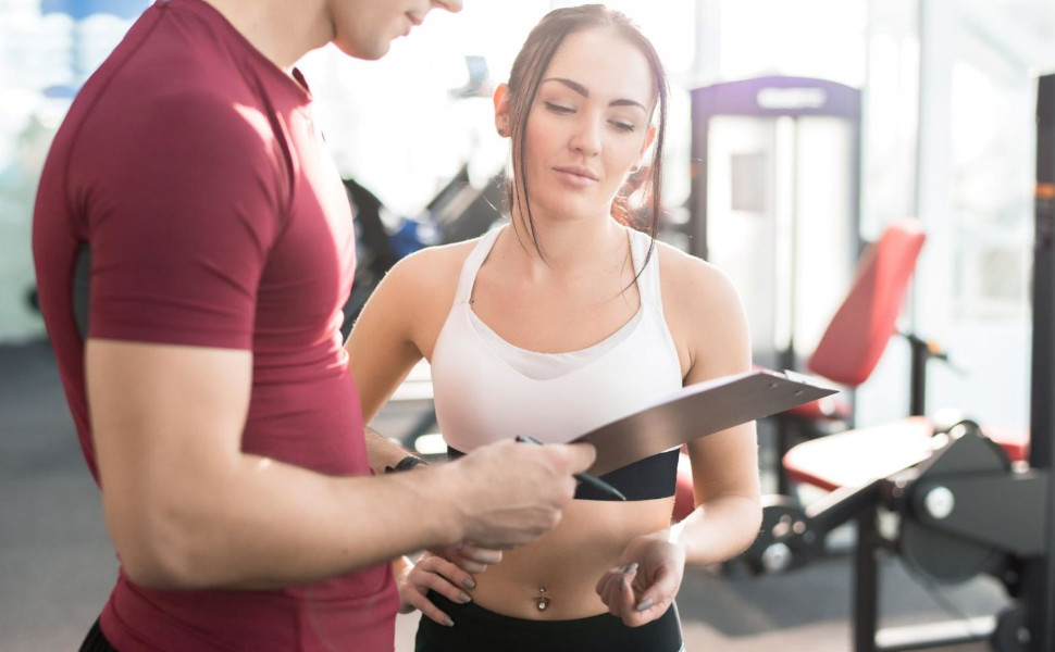 Ein Ernährungscoach berät eine Sportlerin.