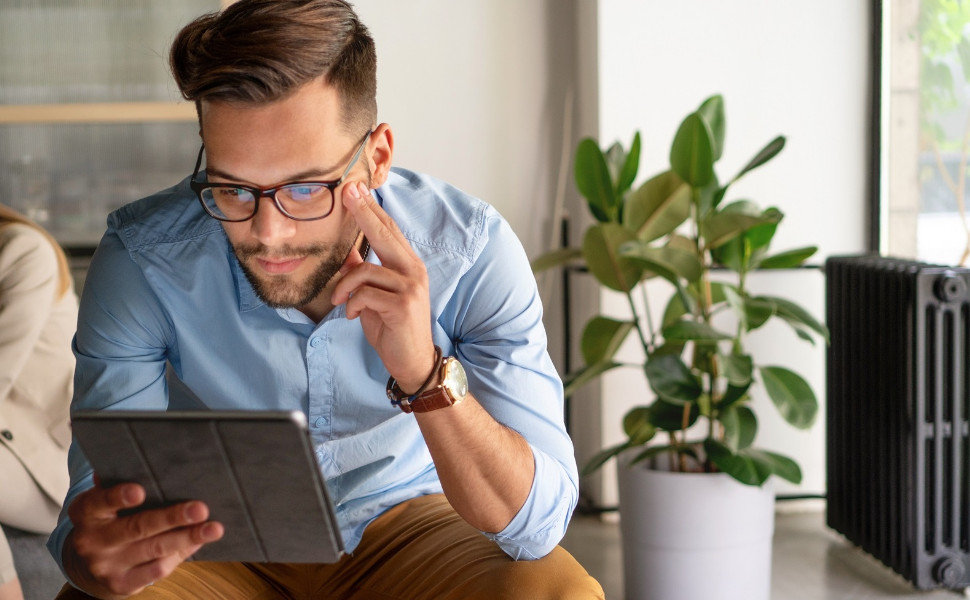 Junger Mann liest auf einem Tablet