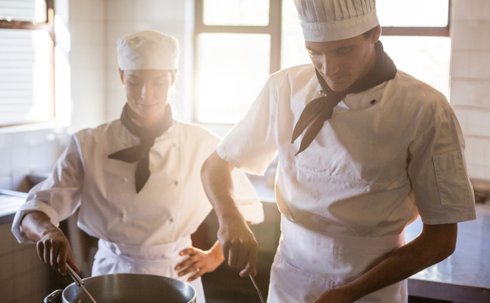 Eine Köchin und ein Koch bei der Arbeit.