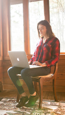 Mädchen mit Laptop auf dem Schoß